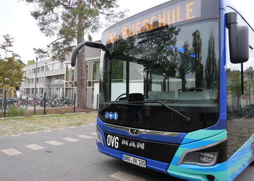 Ein OVG-Bus steht vor einem Schulgebäude.