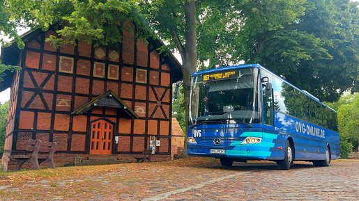 OVG-Bus fährt an einem Fachwerkhaus vorbei.