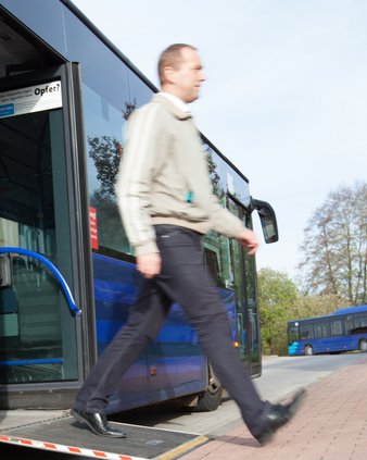 Mann läuft über eine Rampe aus der Mitteltür des Busses.