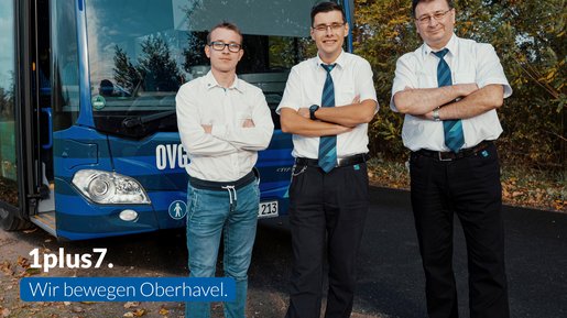 Kampagnen-Foto 1plus7.Wir bewegen Oberhavel. Drei Männer vor der Front eines blauen Busses. Links in der Ecke der Slogan "1plus7. Wir bewegen Oberhavel."