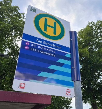Ein Haltestellenschild der OVG mit Streifen in verschiedenen Blautönen wie auf den Bussen und im Logo
