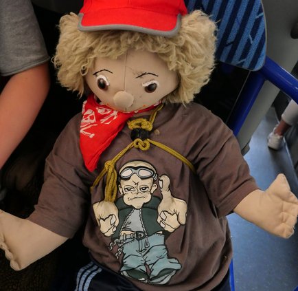 Busschule Puppe sitzt auf einem Busplatz