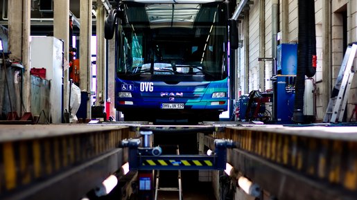 Blauer Bus über Wartungsgrube in der Werkstatt.